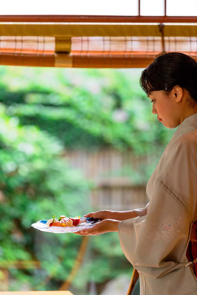 Waitress with sashimi selection